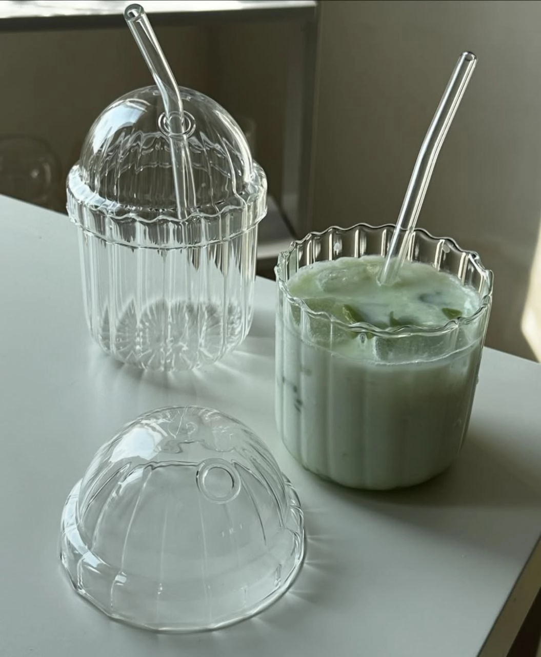 تصویر ماگ اسموتی شیشه‌ای پیرکس با نی و درب، طراحی کاربردی برای سرو نوشیدنی‌ها